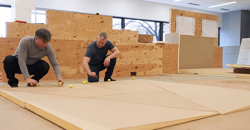Men using golf balls to show tapered roof slope
